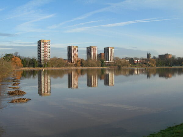 An image of some tall buildings next to water